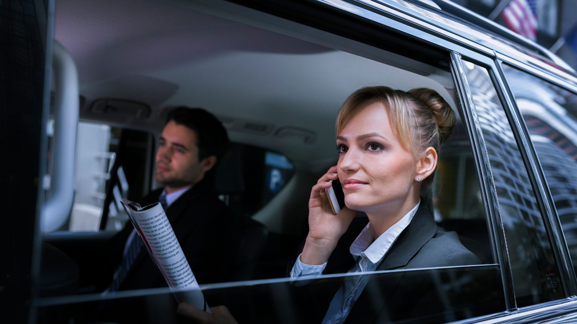 A woman with magazine in hand and talking on phone looking out of window sitting in a limousine A woman with magazine in hand and talking on phone looking out of window sitting in a limousine